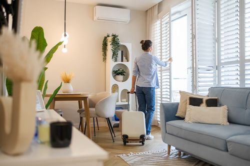 © pikselstock - stock.adobe.com Foto: Frau öffnet Fenster in Wohnung